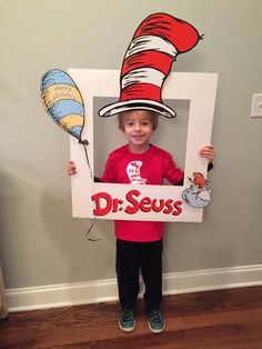 a young boy holding up a dr seuss sign