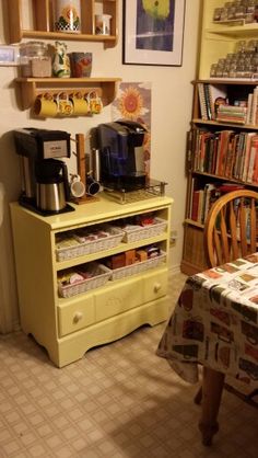 a kitchen with a yellow dresser and coffee maker