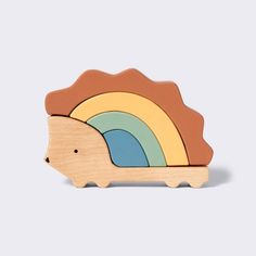 a wooden toy hedge with a rainbow in the background