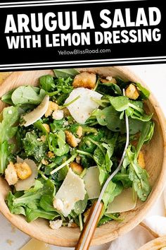 a salad with lemon dressing in a wooden bowl on top of a white tablecloth