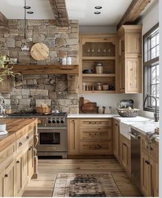 a rustic kitchen with stone walls and wooden cabinets, wood flooring, and an area rug