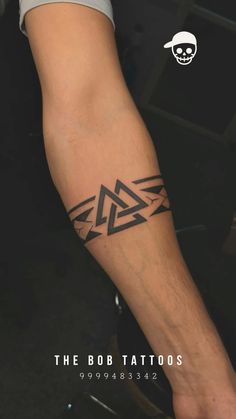 a man with a tattoo on his arm that has an arrow in the shape of a triangle