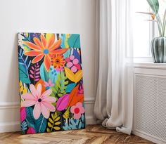 a painting on the floor next to a window with curtains and a potted plant