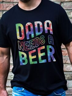 a man wearing a dad needs a beer t - shirt in front of a brick wall