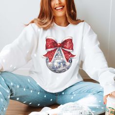 Hey there, holiday disco queen! Bring some sparkle to your festive wardrobe with our "Disco Christmas Bow" Graphic Sweatshirt. Featuring a fun, dazzling bow designed with disco shimmer, this sweatshirt adds a groovy twist to your holiday style. Crafted from ultra-soft, cozy fabric, it’s perfect for keeping you warm and comfortable during all your holiday activities—from tree trimming to dancing at holiday parties. The eye-catching design combines festive flair with disco vibes, making it the ultimate statement piece this season. Pair it with jeans or leggings for a fun and festive outfit that’s ready to dazzle. Shine bright and get your groove on with this unique holiday sweatshirt! 🎀✨ Designs are printed with direct to garment, high quality ink. Christmas Sequin Top For Festive Occasions, Christmas Party Crew Neck Sweater, Sequin Top For Christmas Holiday, Winter Disco Long Sleeve Top, Disco Style Long Sleeve Winter Tops, White Crew Neck Sweater For Parties, Casual Sequin Party Sweater, Winter Party Sweatshirt With Crew Neck, Winter Party Crew Neck Sweatshirt