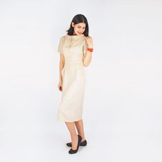 "This 1950s day dress is a classic sheath in cut. It is made of unlined rayon butcher cloth, very much like linen in look and feel, and in a linen-like natural color. There is a wide stand-up collar with picot trim and burnt orange accent fabric. A small self-fabric bow embellishes the center front. There are angled front pockets, a back kick pleat and a side covered metal zipper. There is no label in the dress, but it definitely appears commercially made. CONDITION: Just back from my eco-friend Classic Fitted Linen Dress For Daywear, Fitted Linen Dress With Short Sleeves For Work, Fitted Short Sleeve Linen Dress For Work, Cream Linen Fitted Midi Dress, Fitted Cream Linen Dress, Fitted Cream Linen Midi Dress, Beige Fitted Linen Daywear Dress, Beige Fitted Knee-length Linen Dress, Fitted Beige Linen Dress For Daywear