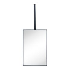 a square mirror hanging from the side of a metal pole with a light on top