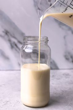 milk being poured into a glass jar