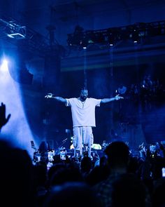 a man standing on top of a stage in front of a crowd