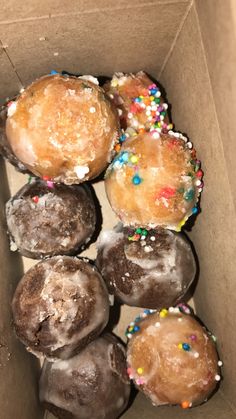 a box filled with donuts covered in frosting and sprinkles