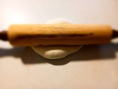 a wooden rolling pin sitting on top of a white counter next to a ball and bat