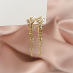 The pair you'll reach for again and again. Add a touch of sparkle to your life with these shimmering gems, designed to complete any look. Handcrafted with a sterling silver base, 14k gold plating and cubic zirconia, these earrings are truly one of a kind. Measuring 40mm in height, they are the perfect accessory to dress up any outfit. Whether you're heading to a party or just running errands, these earrings will add a touch of elegance to your day. Glamorous Cubic Zirconia Drop Earrings, Luxury Sterling Silver Linear Earrings For Party, Fine Jewelry Crystal Earrings With Cubic Zirconia For Party, Cubic Zirconia Bridal Drop Earrings, Fine Jewelry Diamond Dangle Crystal Earrings, Glamorous Cubic Zirconia Crystal Earrings As Gift, Glamorous Cubic Zirconia Dangle Diamond Earrings, Glamorous Cubic Zirconia Earrings With Diamond Accents, Elegant Yellow Gold Chandelier Earrings With Cubic Zirconia