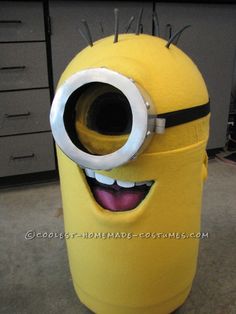 a large yellow trash can with spikes on it's head and eyes painted to look like a minion