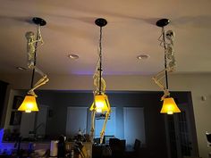 three skeleton lamps hanging from the ceiling in a living room with blue lights on them