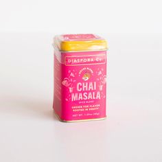 a canister of chai masala sits on a white surface with a yellow top