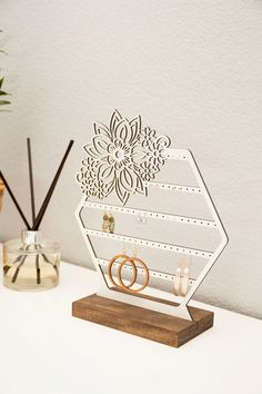 a couple of rings sitting on top of a wooden stand in front of a plant