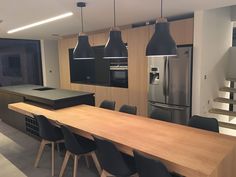 a kitchen with an island table and black chairs