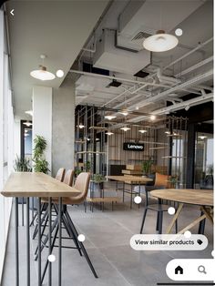 an office with tables, chairs and plants in the middle of the room on either side of the desks