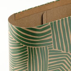 a close up of a green and white pattern on a cardboard box with brown paper