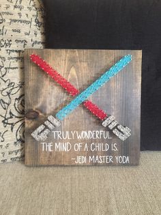 a wooden sign with two crossed swords on it that says, truly wonderful the mind of a child is - jedi master yoda