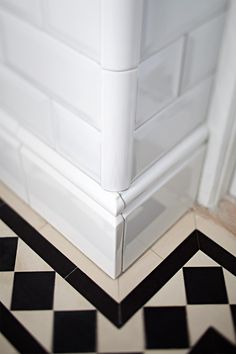 a black and white checkered floor next to a wall with a toilet in it