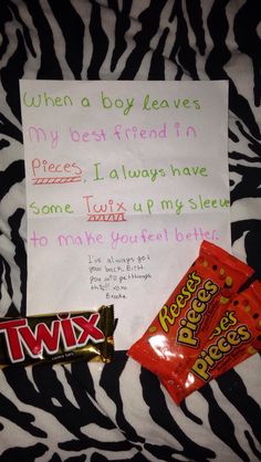 a candy bar and two pieces of paper on a zebra print blanket with a message written to them