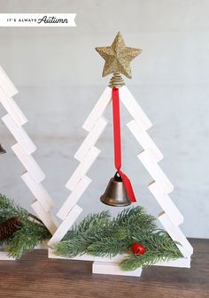 two wooden christmas trees with bells on them