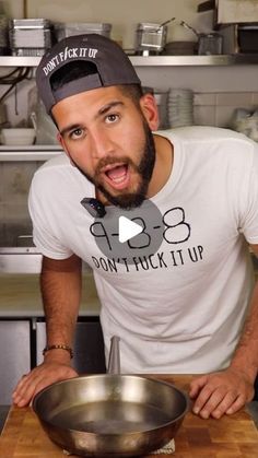 a man in a kitchen with a frying pan