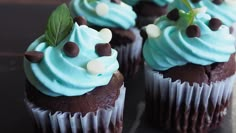 chocolate cupcakes with blue frosting and mint sprinkles on top