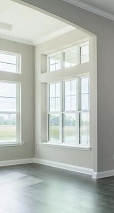 an empty room with three windows and no one in the house or someone is using it