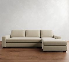 a couch sitting on top of a wooden floor next to a white wall in an empty room