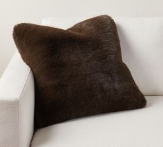 a brown pillow sitting on top of a white couch