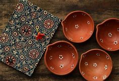 four brown bowls sitting on top of a wooden table