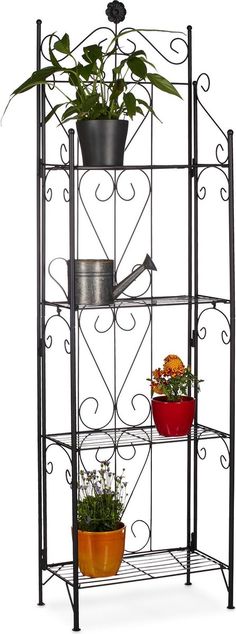 an iron shelf with potted plants on top and two flower pots in the bottom