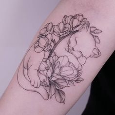 a woman's arm with flowers and a cat tattoo on it