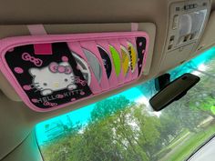 the hello kitty car seat organizer is hanging from the back of a car window with trees in the background