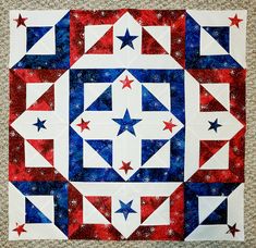 a red, white and blue quilt with stars on it