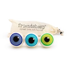 three eyeballs are sitting in front of a bag with the words friendship on it