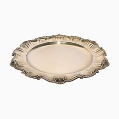 a silver plate with ornate designs on the rim and sides, set against a white background