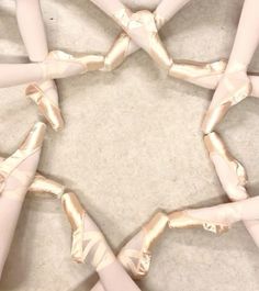 several ballet shoes arranged in a circle on the floor