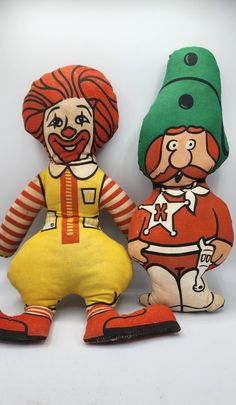 two stuffed clowns sitting next to each other