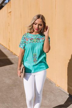 Brighten up your summer wardrobe with our adorable turquoise colored "SanFran Sunshine" top featuring lightweight breeze material patterned with colorful floral embroidery, a high rounded neckline, short loose sleeves, and a relaxed silhouette that falls into a straight hemline! You can style this cutie a variety of ways, like with some frayed white skinnies and a neutral wedge and clutch, but you can also wear it with some distressed denim shorts, our "So Relatable Heel in Red," our "Island Lux Neutral Wedges, White Skinnies, Plaid Poncho, Loose Sleeves, Impressions Online Boutique, Rounded Neckline, Distressed Denim Shorts, Model Fits, Turquoise Color