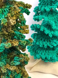 two crocheted christmas trees sitting next to each other