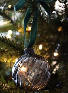 a glass ornament hanging from a christmas tree