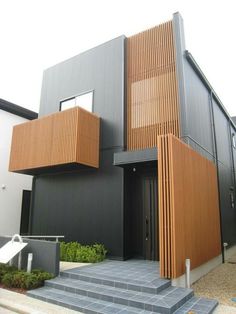 a modern house with wood slats on the side and stairs leading up to it