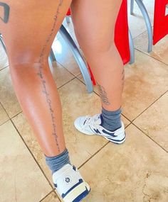 the legs and ankles of a woman with tattoos