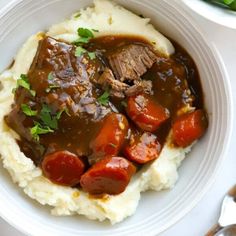 a white plate topped with mashed potatoes and meat