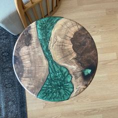 a wooden table with a green river in the center on a wood floor next to a chair