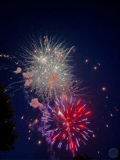 fireworks are lit up in the night sky with red, white and blue lights on them