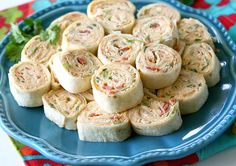 a blue plate topped with rolls on top of a table